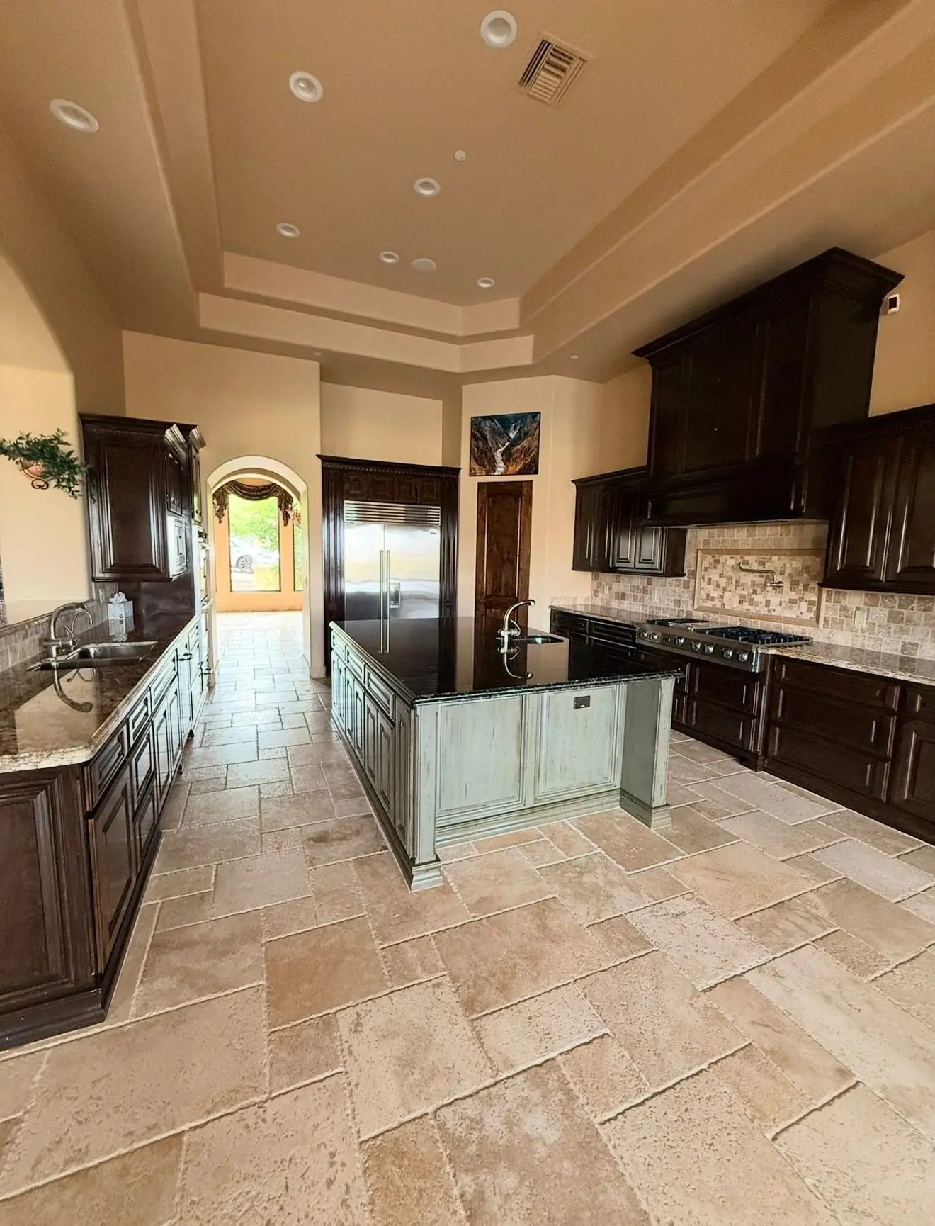 Kitchen with warm beige walls and a stepped two-tone tray ceiling with recessed lights