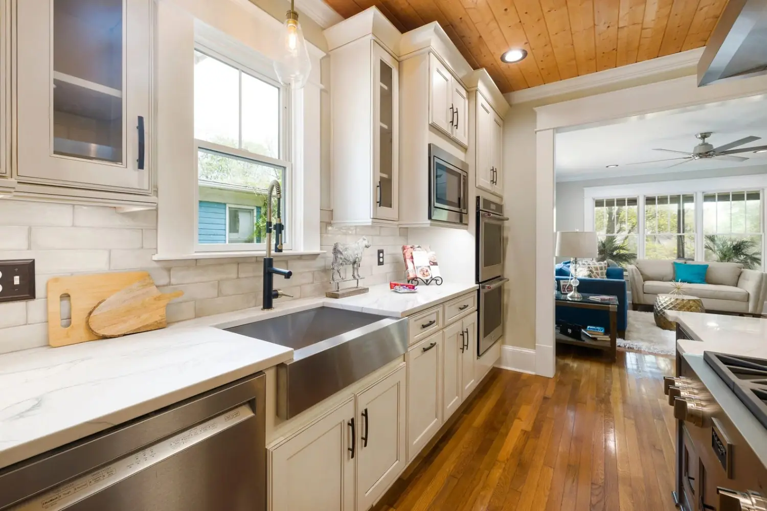 Kitchen with white shaker cabinets, a farmhouse sink, subway tile and a wood plank ceiling