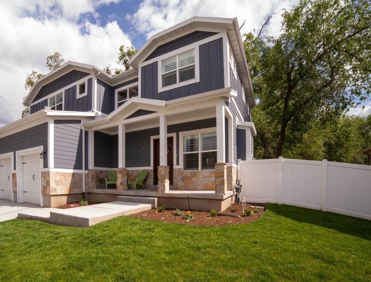 Two-story house with navy lap siding, white trim and stone accents